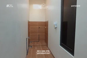 Detail instalasi pipa air dan keramik dinding anti cipratan pada area ruang cuci baju belakang rumah