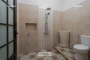 Desain kamar mandi modern dengan shower dan keramik motif pada hunian hasil renovasi