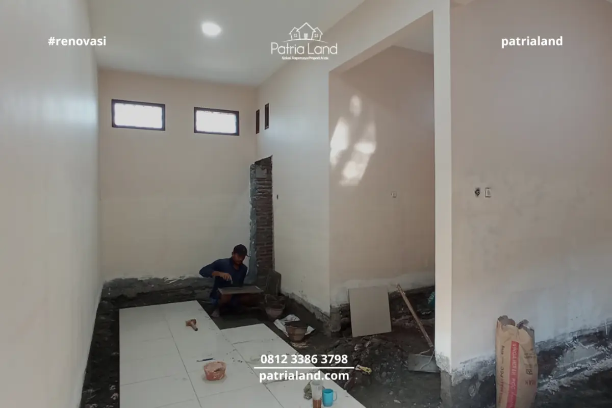 Pekerja Patrialand melakukan pemasangan keramik lantai interior pada proyek renovasi rumah