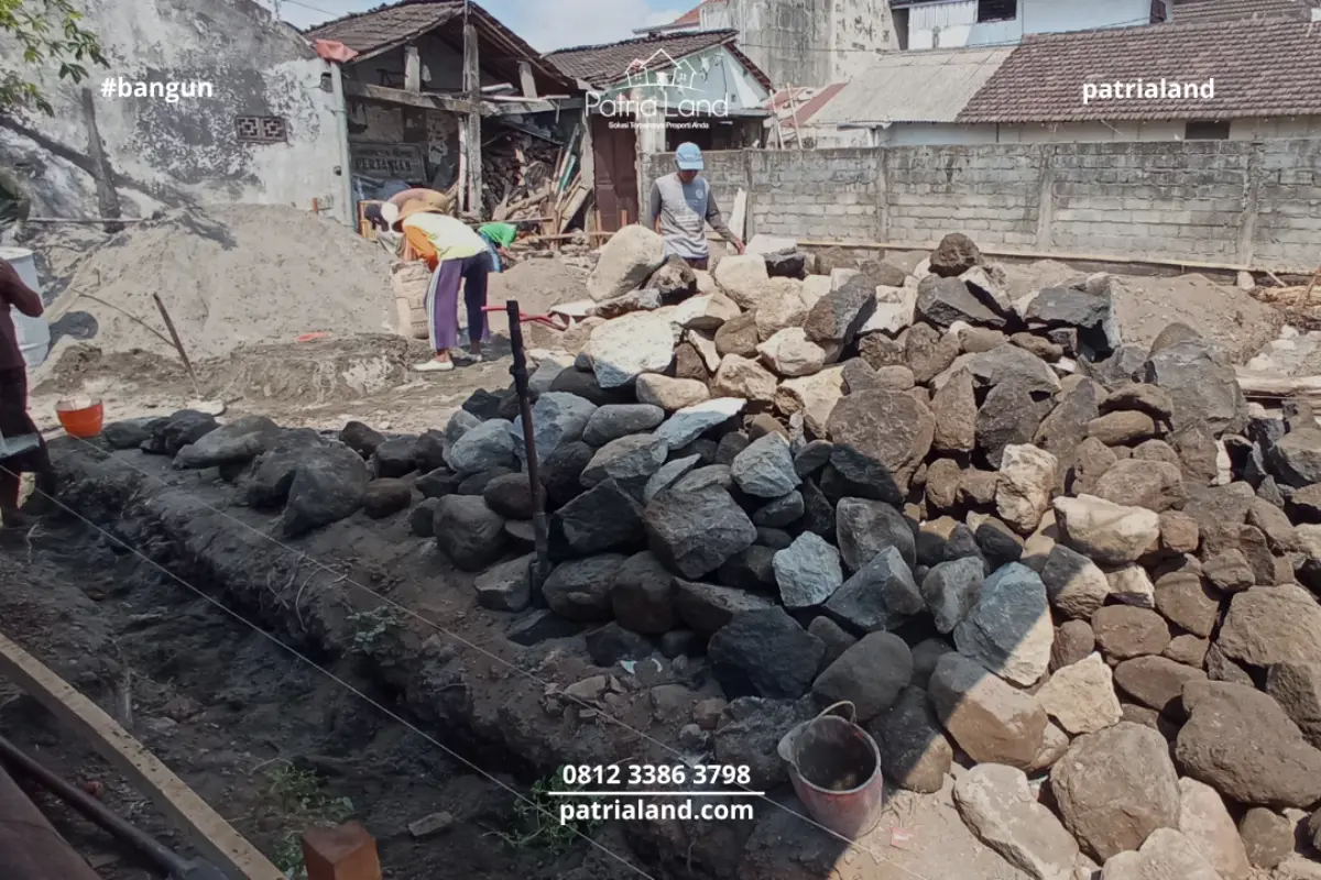 Penyiapan tumpukan material batu kali berkualitas tinggi untuk menjamin kekuatan pondasi bangunan rumah