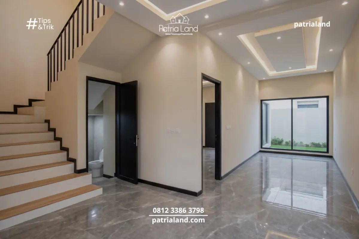 Pengaplikasian lantai granit abu-abu bertekstur marble pada area lantai dua, berpadu serasi dengan railing tangga besi hitam berkonsep minimalis industrial.