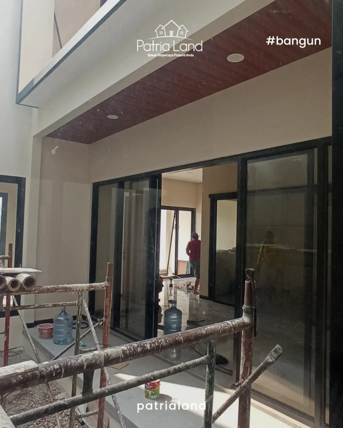 Pintu geser kaca lebar yang difungsikan sebagai partisi ruangan fleksibel tanpa mengorbankan kesan lapang pada interior rumah.