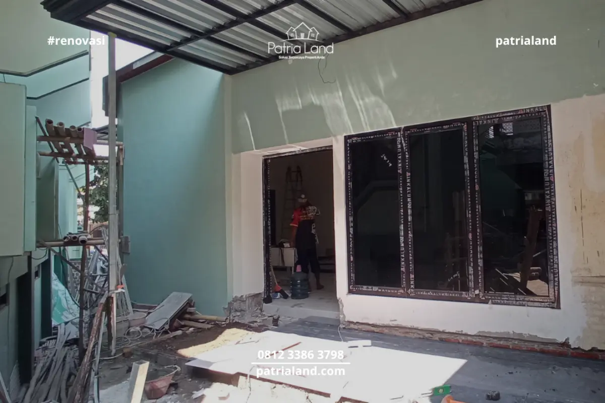 Pemasangan kusen pintu dan jendela aluminium berwarna gelap pada proyek renovasi Wisma Mubaligh Blitar untuk tampilan modern dan awet.