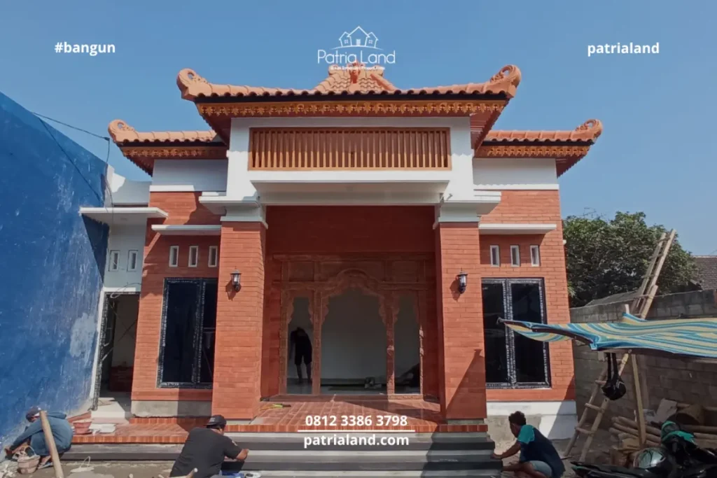 Fasad depan proyek bangun rumah Joglo Jawa modern milik Pak Andri di Talun Blitar oleh Patrialand, menonjolkan bata ekspos dan pintu gebyok.