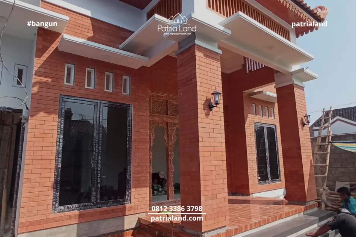 Perpaduan material pilar bata ekspos klasik dengan kusen jendela aluminium hitam yang modern pada proyek rumah Patrialand di Talun.
