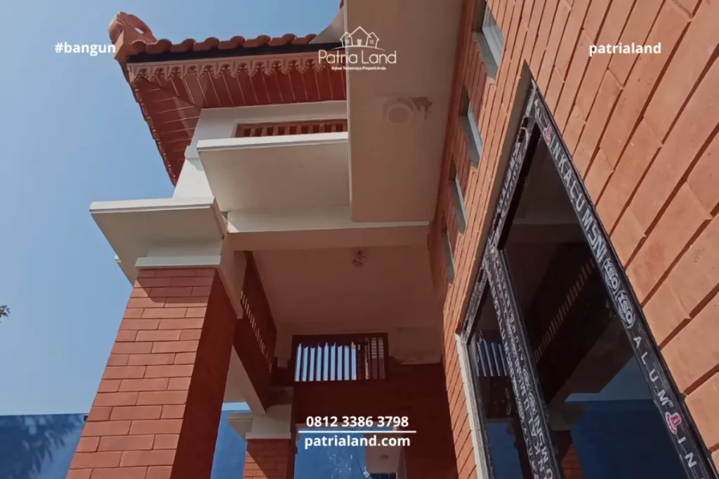 Perpaduan material pilar bata ekspos klasik dengan kusen jendela aluminium hitam yang modern pada proyek rumah Patrialand di Talun.