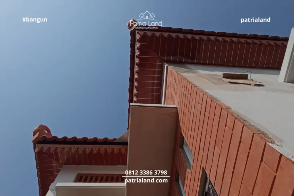 Perpaduan material pilar bata ekspos klasik dengan kusen jendela aluminium hitam yang modern pada proyek rumah Patrialand di Talun.