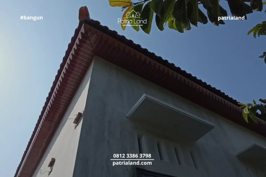 Perpaduan material pilar bata ekspos klasik dengan kusen jendela aluminium hitam yang modern pada proyek rumah Patrialand di Talun.