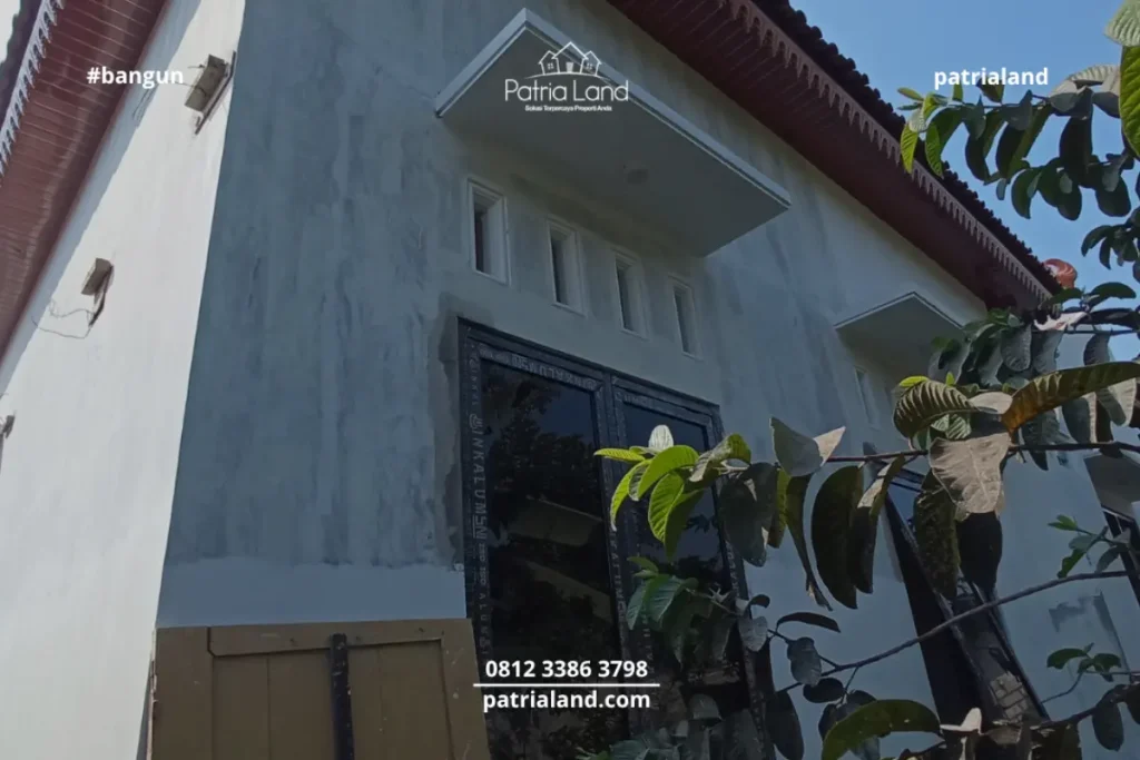 Perpaduan material pilar bata ekspos klasik dengan kusen jendela aluminium hitam yang modern pada proyek rumah Patrialand di Talun.