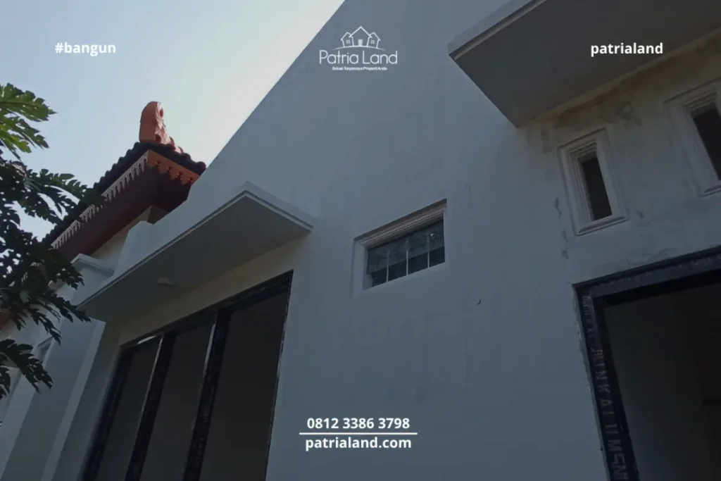 Perpaduan material pilar bata ekspos klasik dengan kusen jendela aluminium hitam yang modern pada proyek rumah Patrialand di Talun.